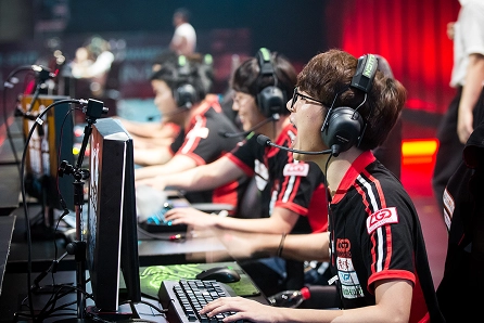 Egy e-sportcsapat, amely egy profi játékversenyen a színpadon, a számítógépek előtt koncentráltan játszik.